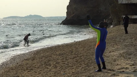 Slow motion of swimmers on the beach during cold winter. Stock Footage 108523532
