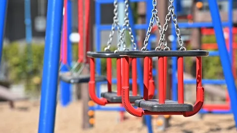 Slow motion of swings at empty children playground in residential area of Stock Footage 129493430