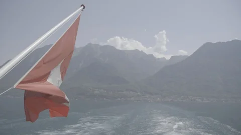 Slow motion Swiss flag on back of boat with Lake Geneva and mountains behind Video stock 123466316