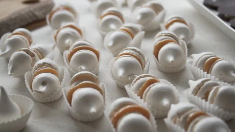Slow motion on table with meringues stuffed with delicacy, close up Stock Footage 240942073