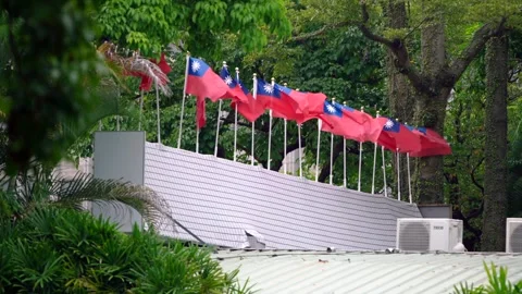 Slow motion of Taiwan flags waving along a rooftop fence Stock Footage 313950267