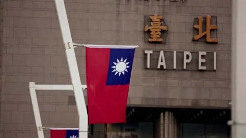 Slow motion Taiwanese flags wave beside a stone building with Taipei lettering Stock Footage 313950039
