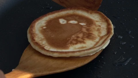 Slow motion of taking batter cake away from hot dark gray fry pan close up. Stock Footage 100235589