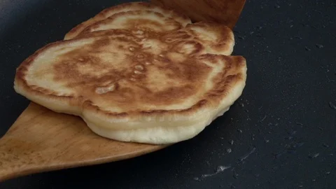Slow motion of taking batter cake away from hot dark gray fry pan close up. Stock Footage 100235859