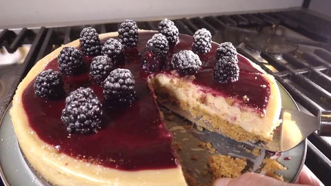 Slow motion: Taking a slice of freshly baked blackberry cheesecake. Video stock 89173205