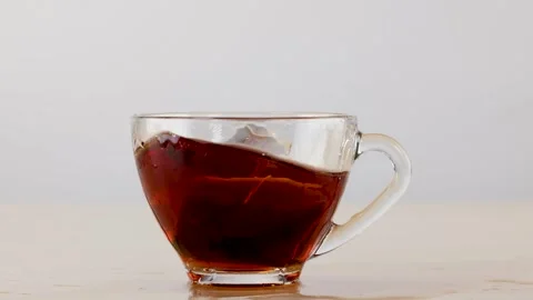 Slow Motion Tea Bag Splash in Clear Glass Cup Stock Footage 341933310