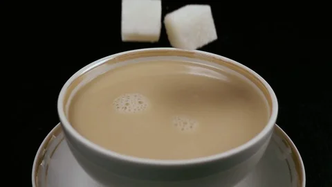 Slow motion. In the tea with milk fall sugar Stock-Footage 75811241