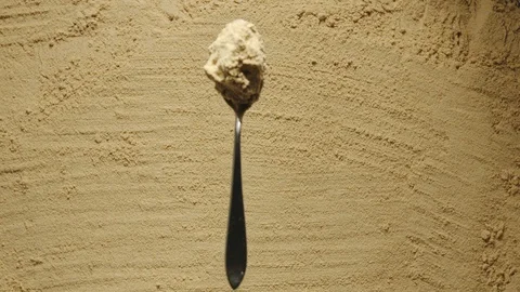 SLOW MOTION: Teaspoon with ginger falls onto a heap of ginger powder Stock Footage 107932561