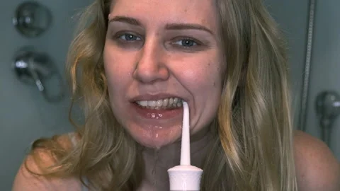 Slow motion of teeth cleansing by irrigator. Young woman cleans her teeth Video stock 134711678
