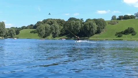 Slow motion of tense man wakeboarding in a lake and being pulled by a rope Stock Footage 106597353