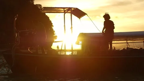 Slow motion of Thai Men working on a Boat Restaurant at Sunset with lense flares Stock Footage 292911700