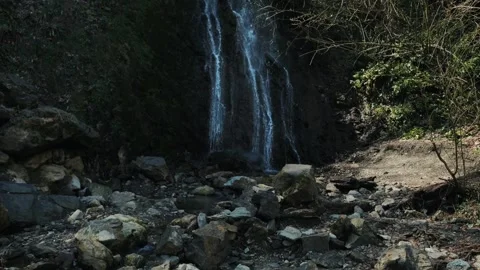 Slow Motion: Thin Forest Waterfall Cascading Down Dark Cliffs Stock Footage 270458334