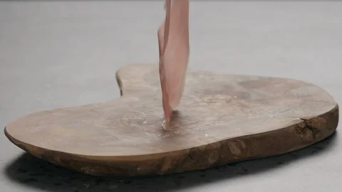 Slow motion thin prosciutto slices falling on wood board Stock Footage 126756753