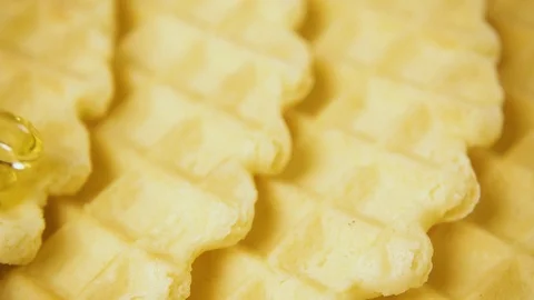 Slow motion a thin trickle of honey pours onto the waffles Stock Footage 85473661