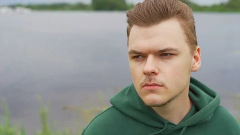 Slow motion of A thoughtful young man who is staring away at the river Stock Footage 91230955
