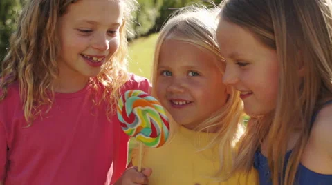 Slow motion of three children licking lolly in park. Stock Footage 43673567