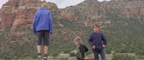 Slow Motion Three Children Playing in the Rocky Desert Stock Footage 61835447