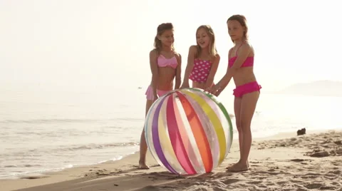 Slow motion of three children pushing beach ball on beach. Stock Footage 43673048