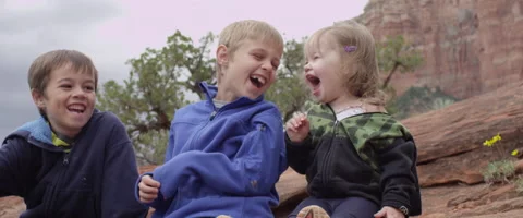 Slow Motion Three Kids Sitting and Laughing Together Stock Footage 61837744