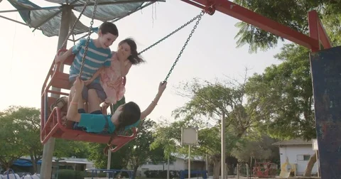 Slow motion of three kids on a swing Stock Footage 77969631