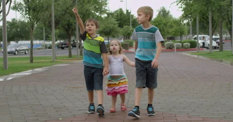 Slow Motion Three Siblings Walking on a Path and Pointing Stock Footage 61651837