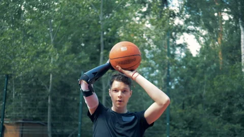 Slow motion throwing of a basket-ball by a teenager with a robotic bionic hand Video stock 95323534