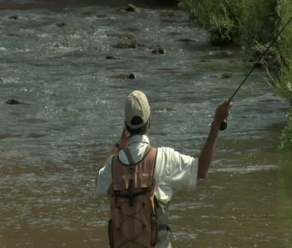 Slow motion tight shot of fly fisherman and red rock cliffs Stock Footage 21680157