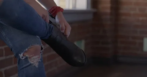 Slow-motion tilt from boot to close up of blonde woman sitting 4K Stock Footage 61679204