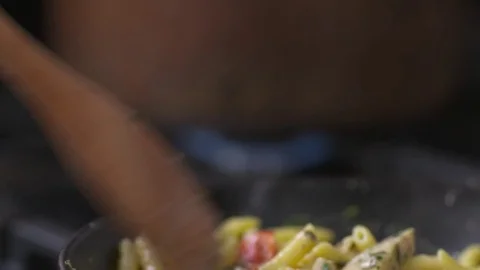 Slow motion tilt down of chicken alfredo simmering on a stove top. Stock Footage 72538425