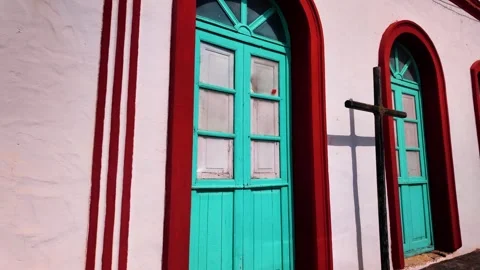 Slow motion tilt down of turquoise doors and wooden cross, Teguise, Lanzarote Stock Footage 346376501