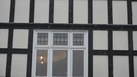 Slow Motion. A tilt shot of windows of a house during a snowfall. Stock Footage 147231506
