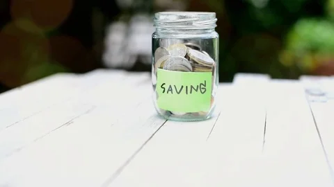 Slow motion tilting camera in of saving coin in can tag saving  Stock Footage 79612749