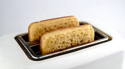 Slow motion time-lapse of crumpets being toasted and popping out of toaster Stock Footage 46879644