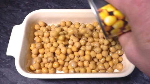 Slow motion – Tin can of cooked chick peas being poured into a dish. Vídeos de archivo 101583110