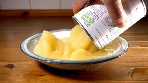 Slow motion: Tinned grapefruit pouring into a bowl. Video stock 88614540