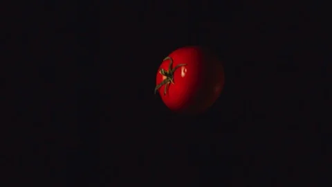 SLOW MOTION: Tomato flies up and falls down on a black background Stock Footage 99672875