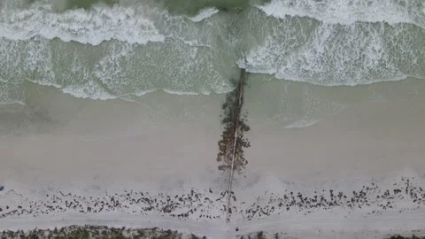 Slow motion top down aerial shot of waves crashing on a beach during the day Stock Footage 138745187