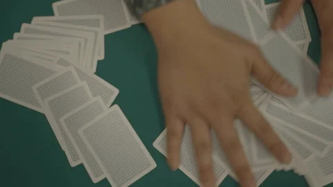 Slow motion top-down cards shuffled on green felt Stock Footage 334037104