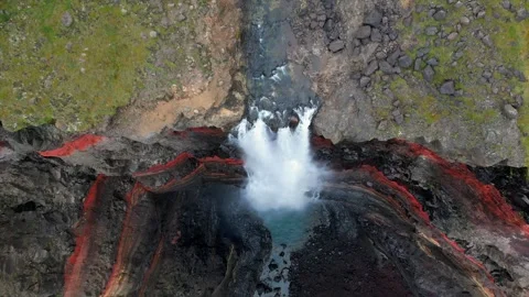 Slow Motion Top-Down View of Hengifoss Waterfall and Vibrant Canyon Layers in Stock Footage 296730385