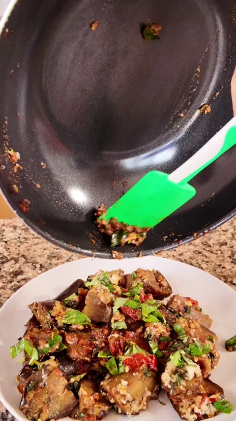 Slow motion, top-down view of a delicious vegetarian meal of sauteed eggplant Stock Footage 344175372