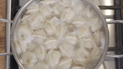 Slow motion top view footage of pan with dumplings in boiling water. Process of Vídeo Stock 128299979