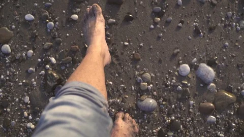 Slow motion of a top view of a man's feet entering the beach at sunset Stock Footage 124834944
