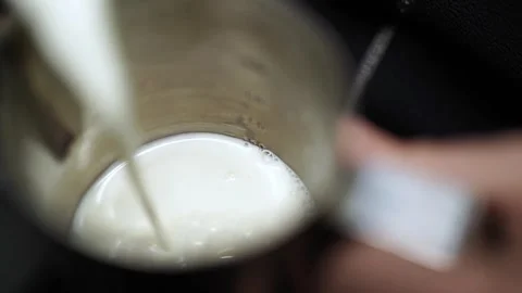 Slow Motion Top View of Milk Pouring into Pitcher with Bubbles Stock Footage 312261515