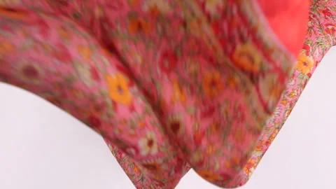 Slow motion top view of a pink silk fabric with a bright orange floral pattern. Stock Footage 337404022