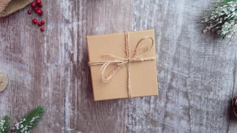 Slow motion top view shot as the camera pulls away from a wrapped gift on a.. Stock Footage 321545048