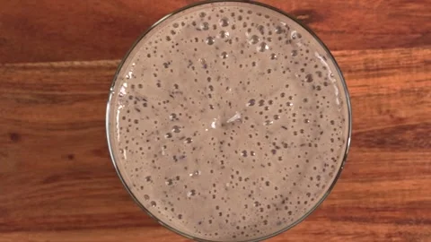 Slow motion top view of single blueberry falling into a berry smoothie in g.. Stock Footage 315033554