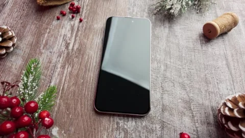 Slow motion top view of a smartphone surrounded by subtle festive elements .. Stock Footage 321545161