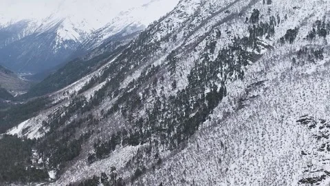 Slow motion. Top view of the snow-capped mountain slopes and the valley.. Stock Footage 166092753