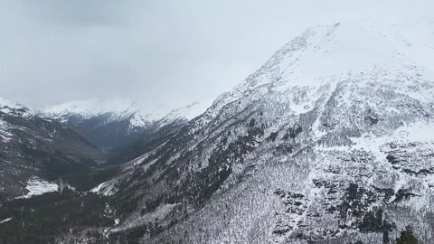 Slow motion. Top view of the snow-capped mountain slopes and the valley.. Stock Footage 166160830