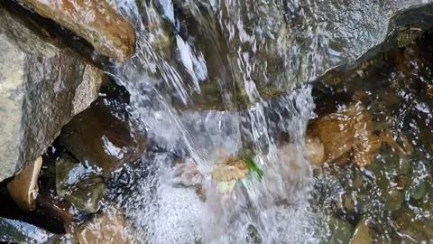 Slow motion top view of water stream flowing over rocks Stock Footage 160888543